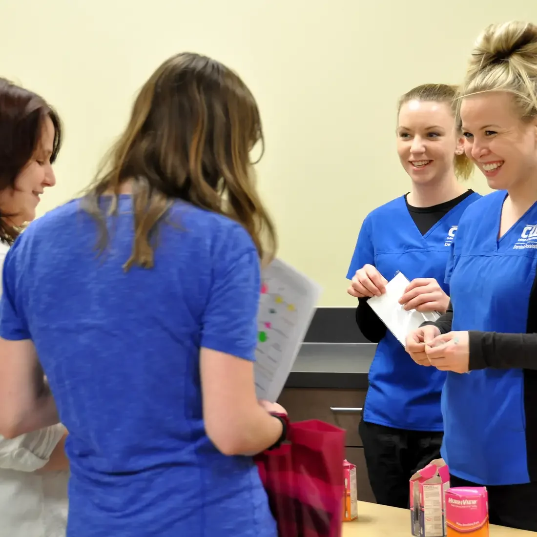 Dental Assisting students speak with visitors during the PACE event in 2015.