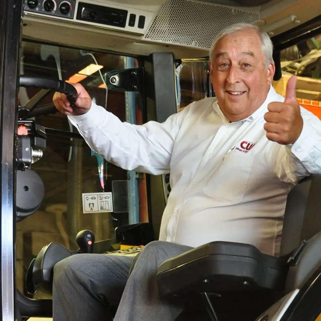 President Bert Glandon sitting in a tractor and giving a thumps up
