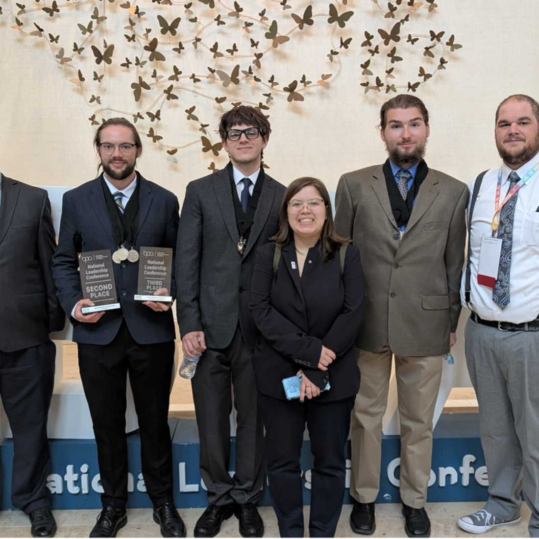 Students pose for a photo holding awards.