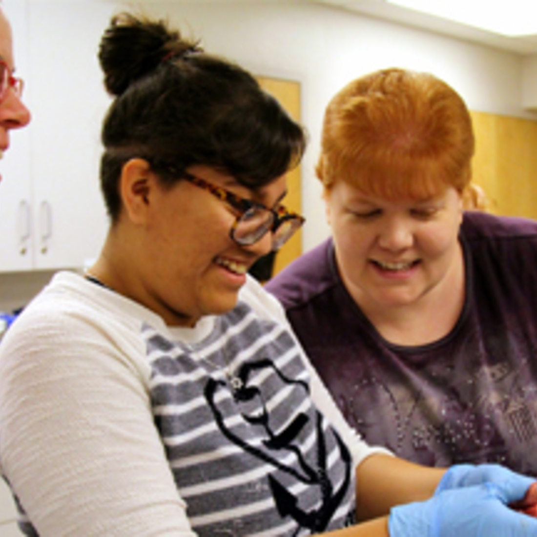 Students looking at pork heart in classroom.