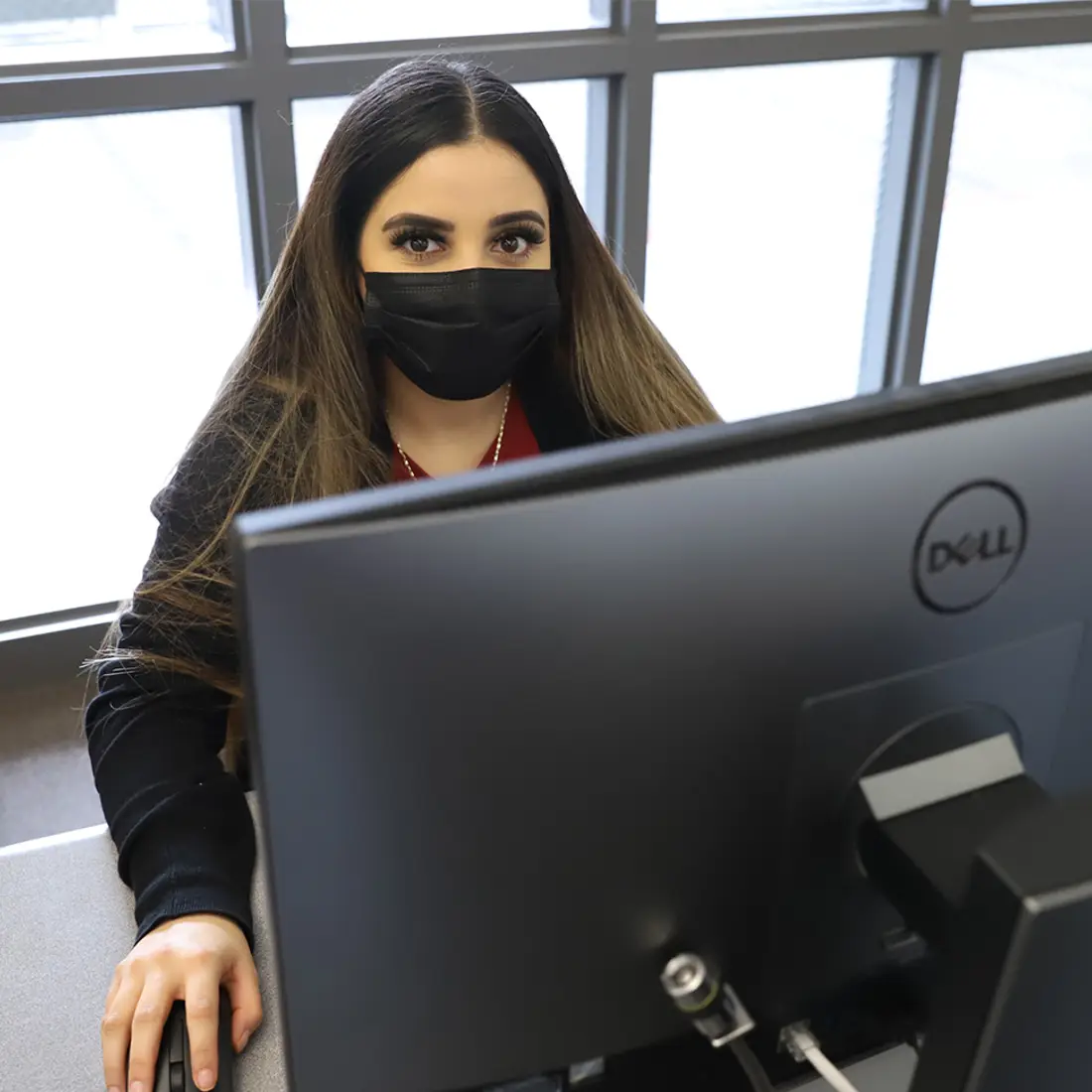 Student at a computer with a mask on
