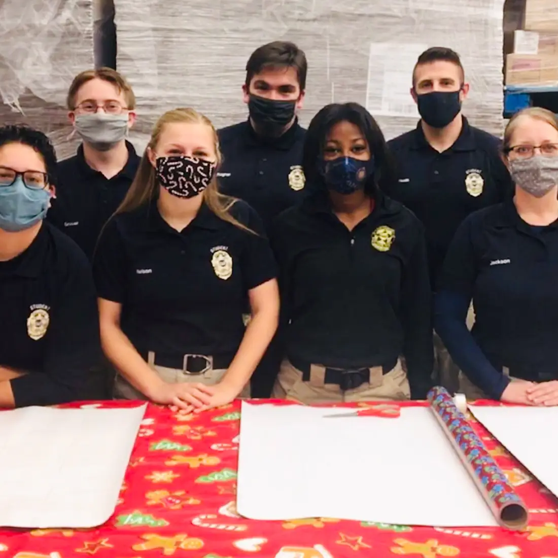 CWI Law Enforcement students helping wrap gifts at Shop With a Cop event