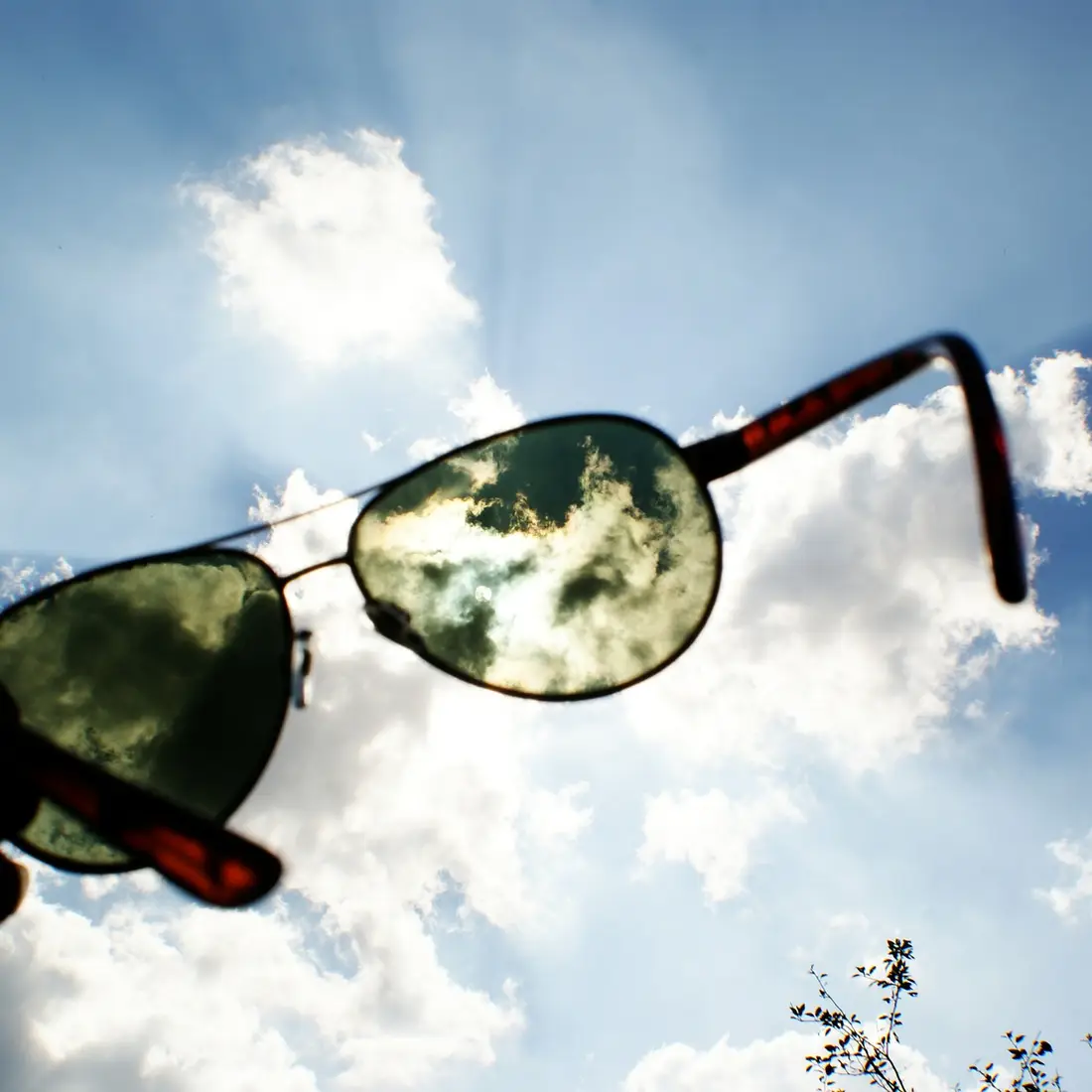 sunglasses being held up in the air