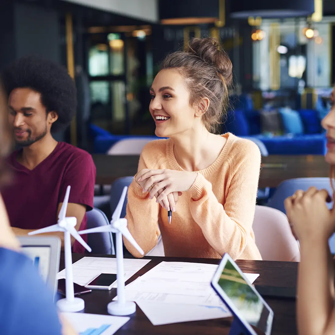 A group of smiling coworks collaborate at a table.
