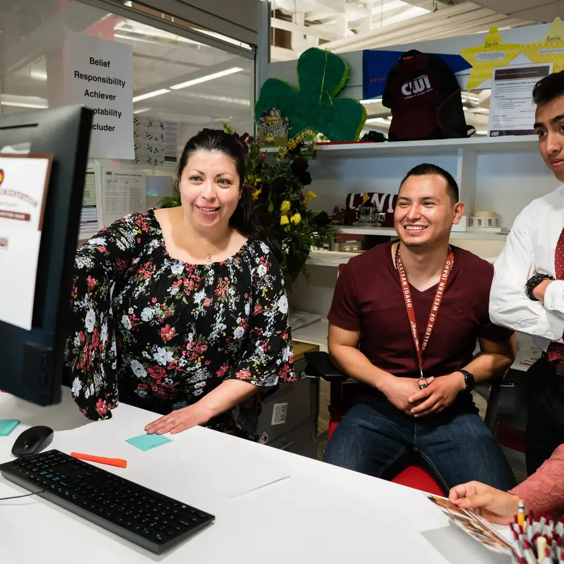 Group of four individuals looking at a computer screen together