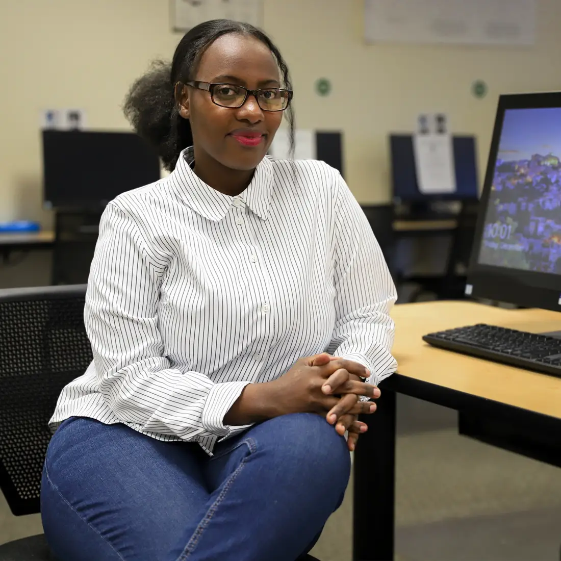 Viviane Akingeneye sitting at computer desk in Tutoring Center