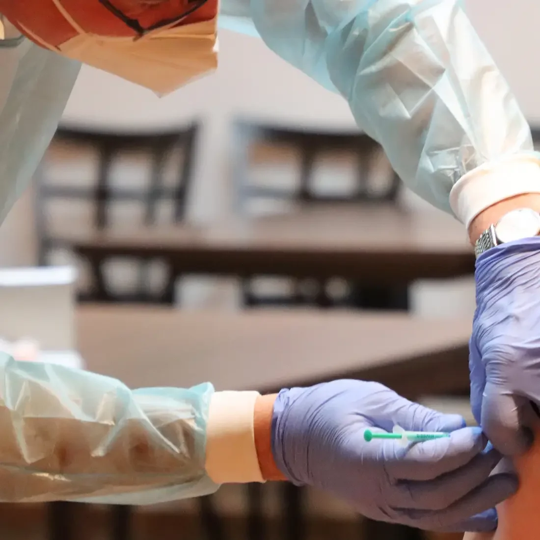 Healthcare worker administering a vaccine to an individual