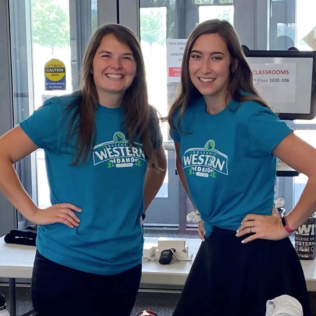 Two employees wearing CWI shirts smiling at the camera