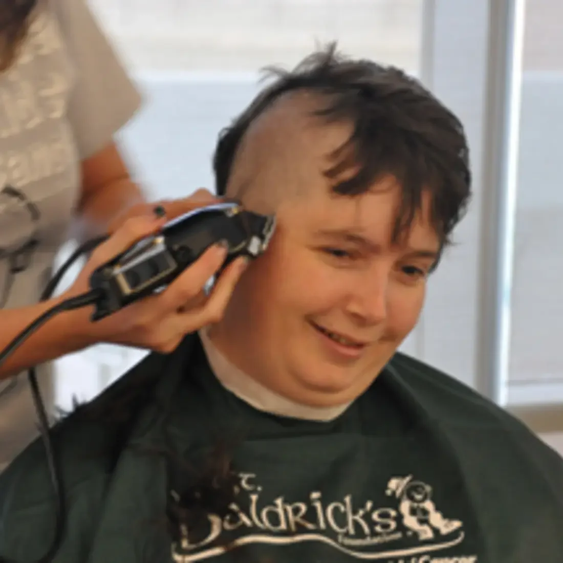 Employee getting hair shaved off