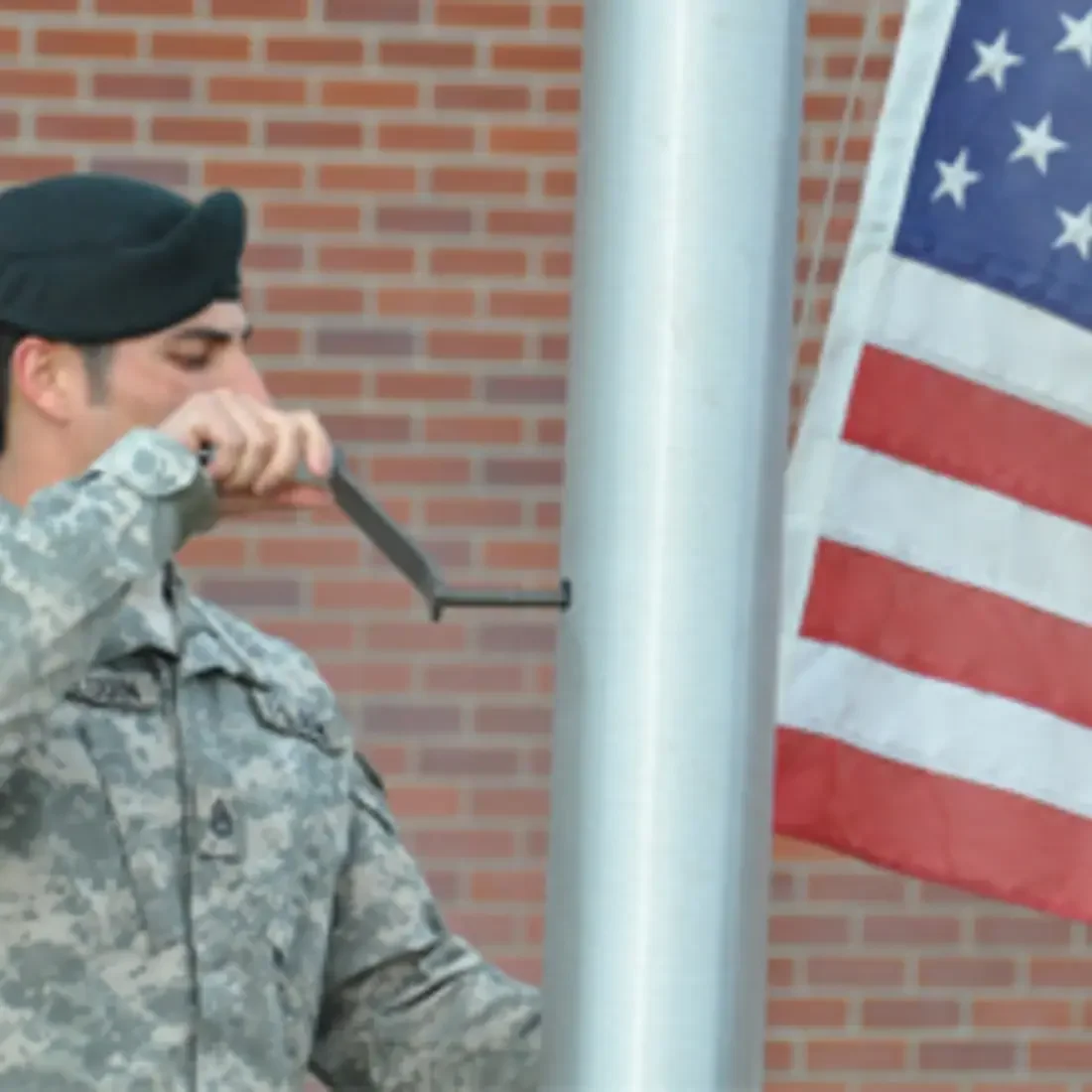Serviceman reaching the flag