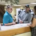 Three people chatting at a front desk