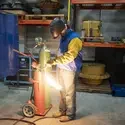 Person welding in a lab with a helmet on