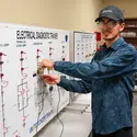 Student at board with wires 