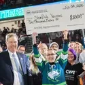 Student holding a large check in front of crowd