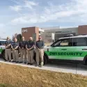 Security team members posing next to a patrol SUV on campus.