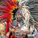 Person in indigenous attire with colorful feathered headdress