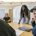 Tutor working with students in front of a whiteboard