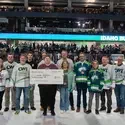 Group of people on ice holding a check