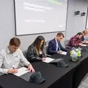 Group of people signing a paper