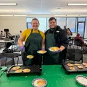 Two people holding plates of pancakes