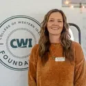 Erin Aboud stands next to CWI banner