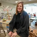 Bronwyn Hitchcock sitting on stool in art classroom