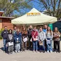 Class stands in front of a pop up tent