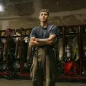 Marquez Arredondo poses in front of firefighter gear