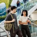 Students wearing a backpack and holding books as they walk down a staircase inside the College's Health & Science Building