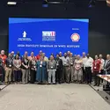 Group of people stand in front of blue screen