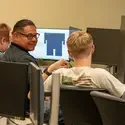 Mentor talks to student in front of computer
