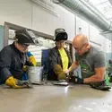 Instructor and students working on welding training