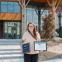 Amber Eubanks holding certificates and plaque