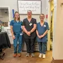 Three CNA students stand in lab