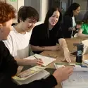 Five students with books and laptops