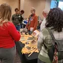 People gathered around table of items