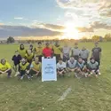 Group of soccer players on a field with a sandwich board sign