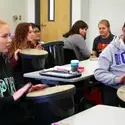 Students using buckets and drum heads in music class.