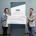 Two people hold a ceremonial check for $1000