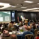 People listen to a speaker during a chamber of commerce luncheon.