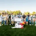A group of people pose for a photo on a baseball field.
