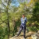 A photo of a man standing on a hiking trail.