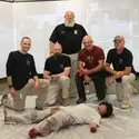 Medical tactical training posing with bleeding mannequin