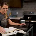 CWI student studying with books and a laptop at home