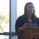 Female student speaking from a podium