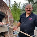 Domingo Garcia, baking pizza in brick oven