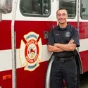 Kemper Hessing stands in front of a CWI fire truck