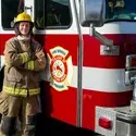 Firefighting student standing next to fire truck
