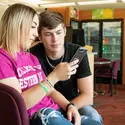 Two students looking at a cell phone 
