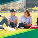 Students sitting on the lawn in front of the Nampa Campus Academic Building talking